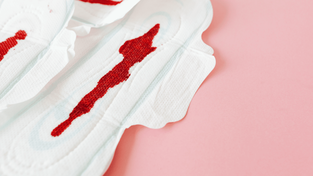 Absorventes com sangue, em fundo rosa.