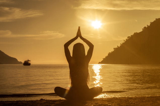 Mulher parada na praia meditando