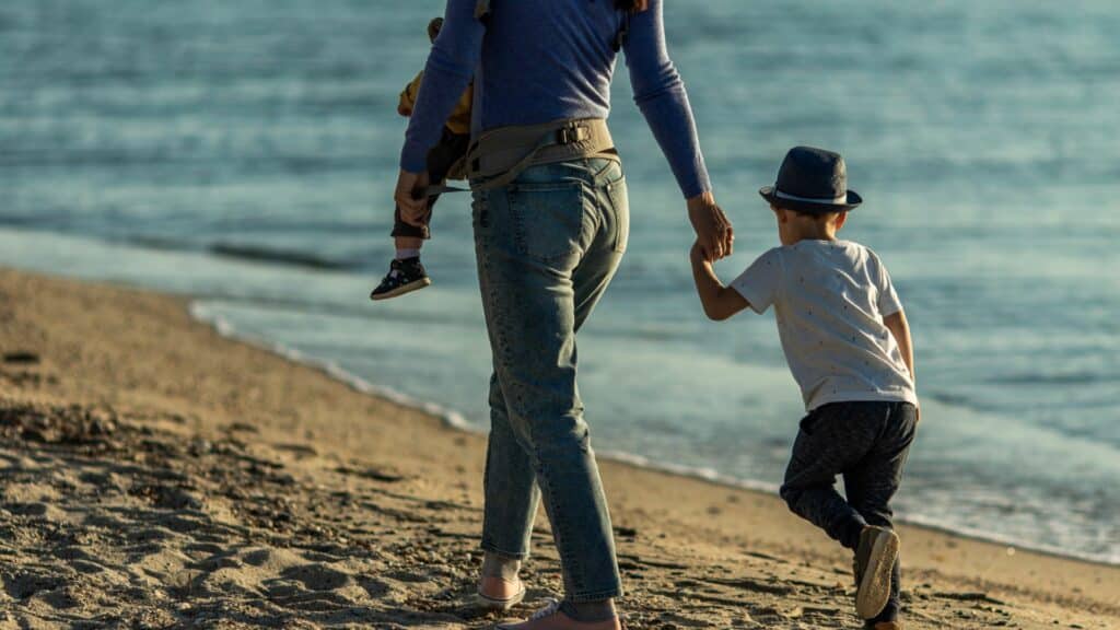 Mãe com os filhos na praia.