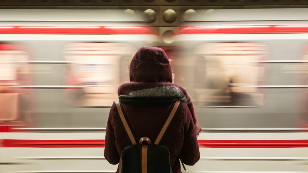 Mulher de mochila vendo o trem passar