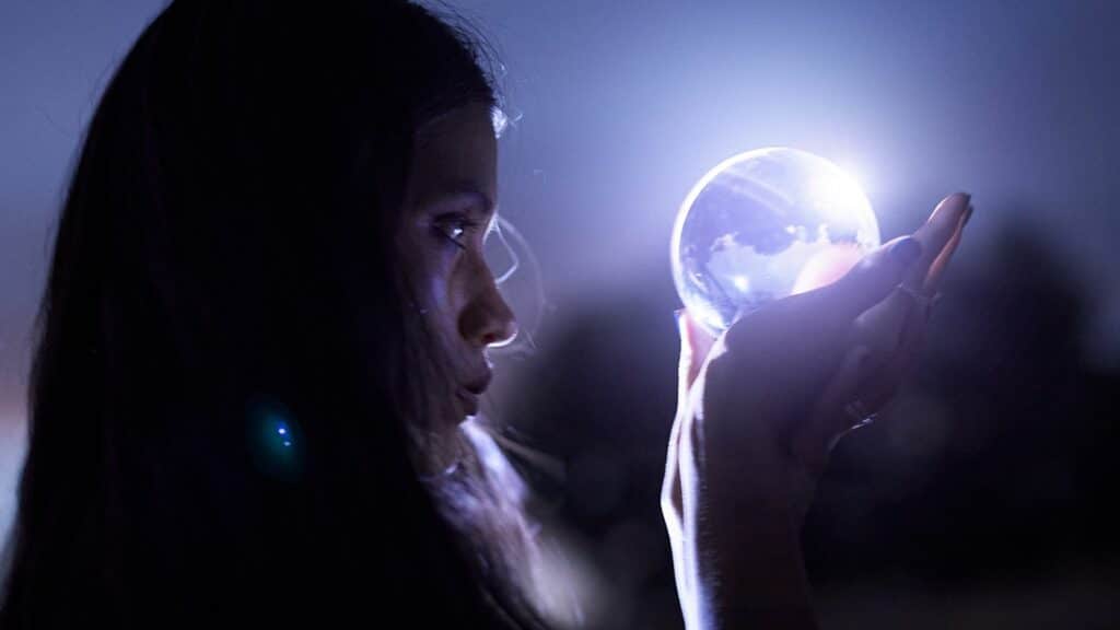 mulher olhando para uma bola de cristal