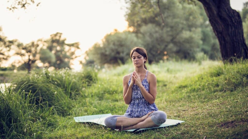 Mulher meditando em uma floresta