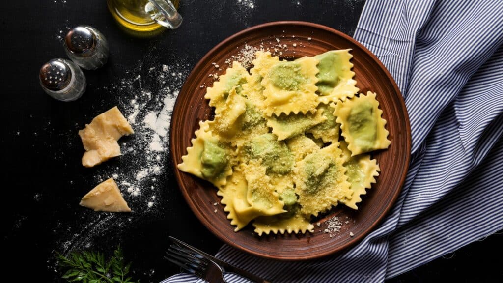 Ravioli de queijo em um prato marrom em cima da mesa