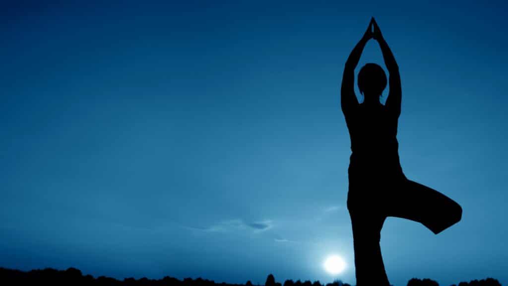 Mulher fazendo Yoga à luz da Lua