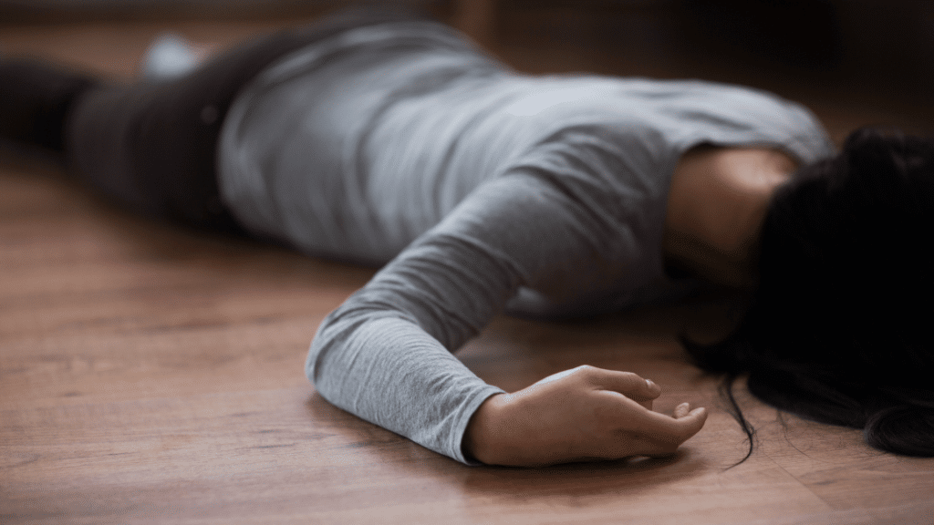 Corpo morto de mulher deitado no chão. Representação de uma cena de crime.