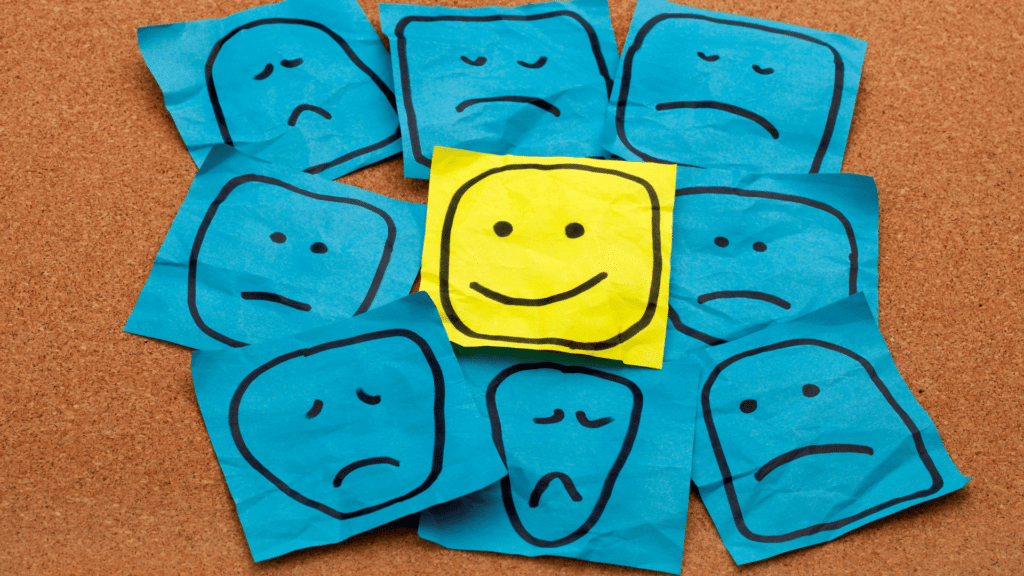 Post-its com rostinhos tristes e somente um feliz desenhados