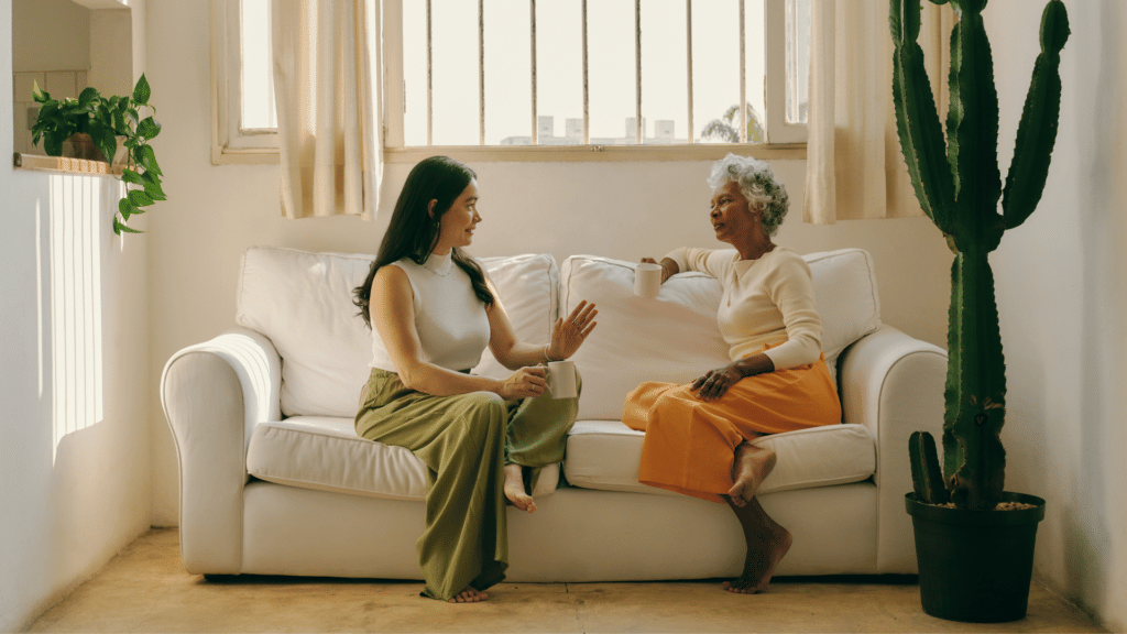 Duas mulheres sentadas no sofá conversando 