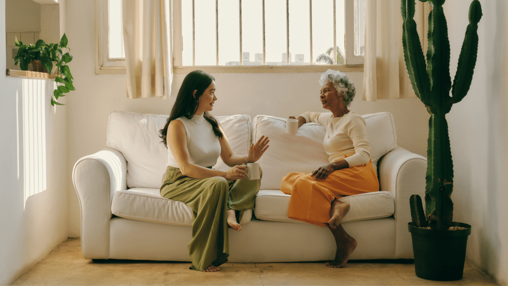 Duas mulheres sentadas no sofá conversando