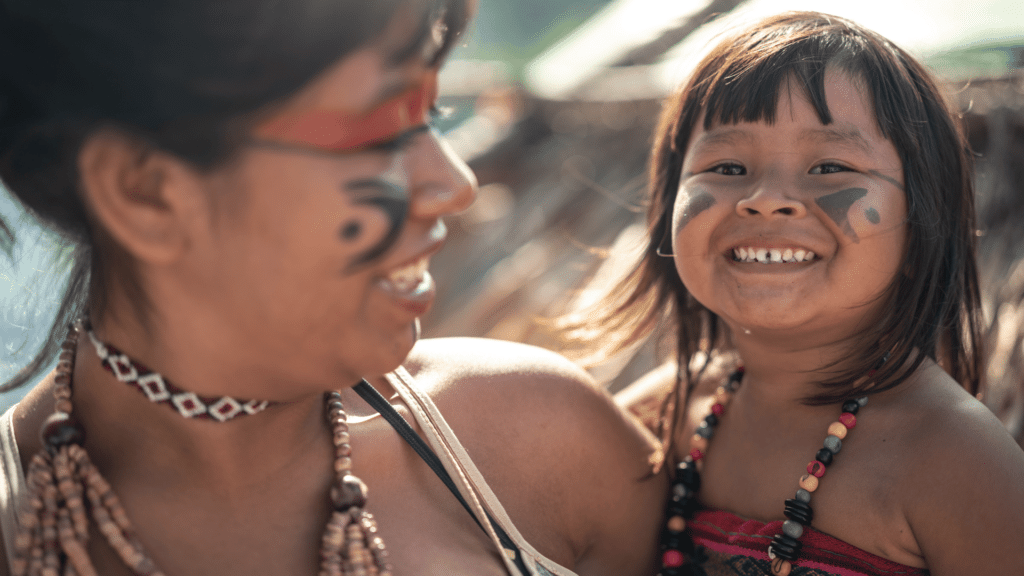 Mulher indígena brasileira segurando criança no colo