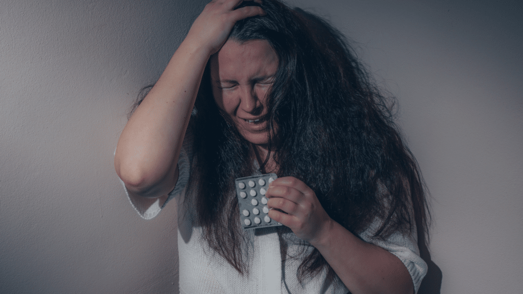 Mulher em estado de confusão, com as mãos sobre a cabeça enquanto chora.