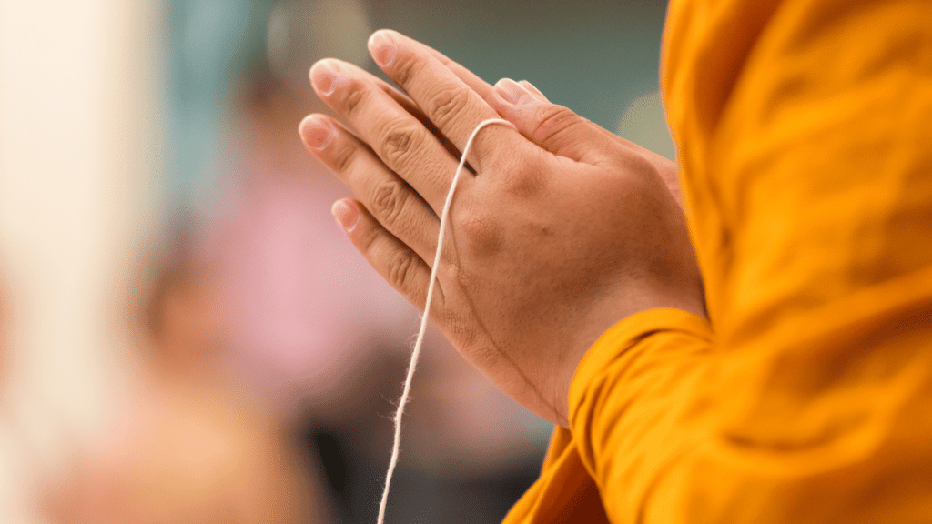 Monge budista com as mãos juntas, em sinal de oração. 