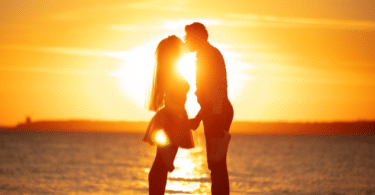 Um casal hétero se beijando na praia