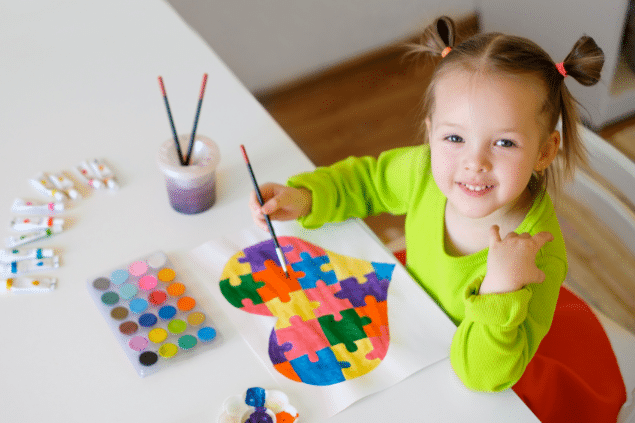 Criança autista pintando um quebra-cabeça