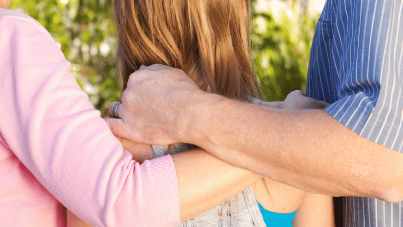 Pais conversando com sua filha, com as mãos sobre suas costas. Conceito de dependência emocional parental.