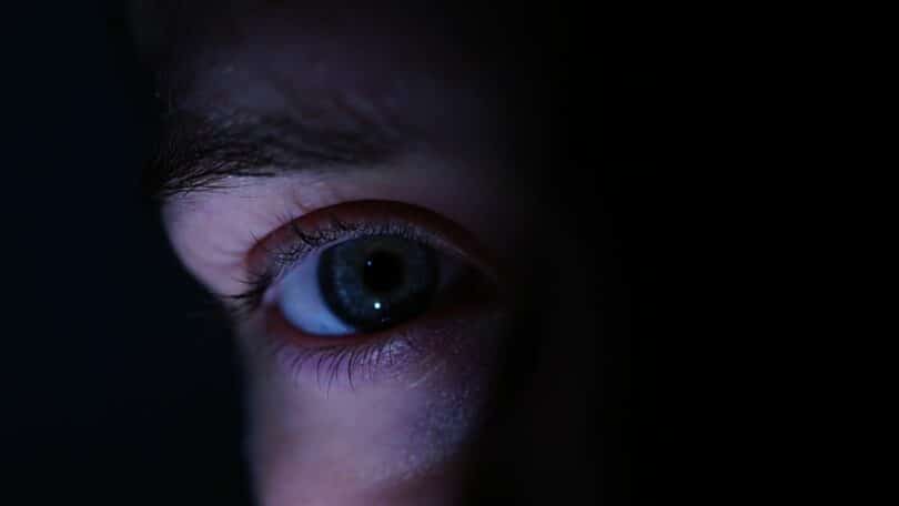 Imagem do olho de uma pessoa no escuro, como se estivesse se escondendo