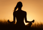 Silhueta de mulher meditando ao por do sol