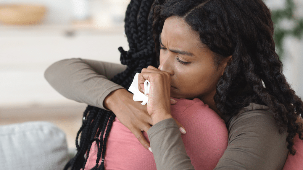 Mulheres se abraçando enquanto uma chora