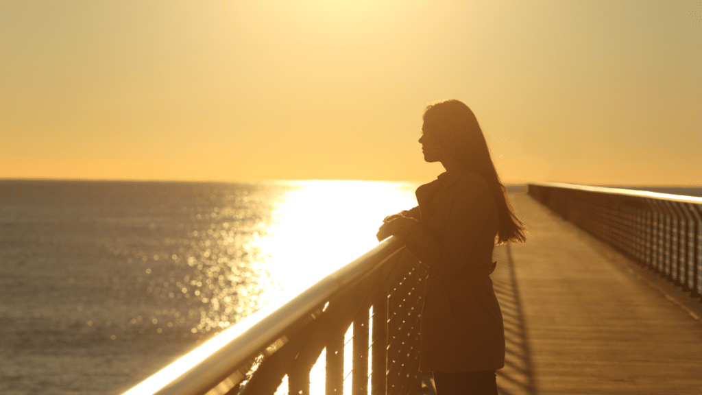 Mulher observando o por do sol sozinha