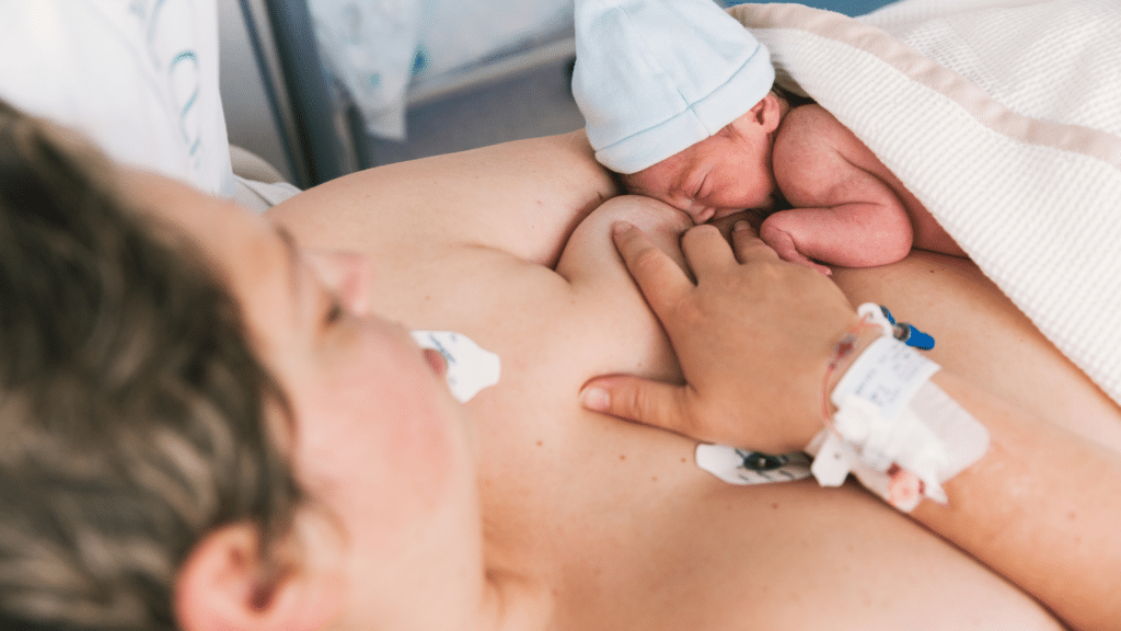Mamãe alimentando seu bebê recém-nascido, enquanto está deitada na cama do hospital. 