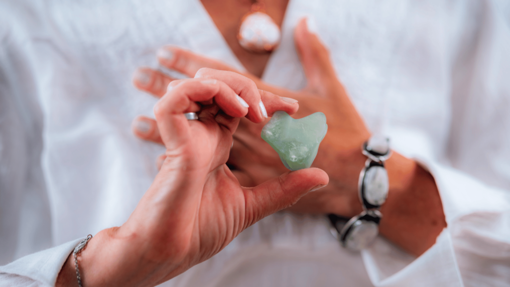 Mulher fazendo meditação com cristal Aventurina nas mãos. 