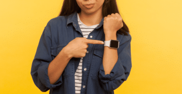 Mulher apontando para relógio de pulso, estilo Smartwatch, em seu braço.