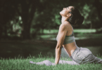 Mulher asiática fazendo posição de yoga no jardim. Ela está se alongando.