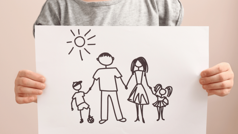 Criança com desenho de família. Conceito de Adoção.