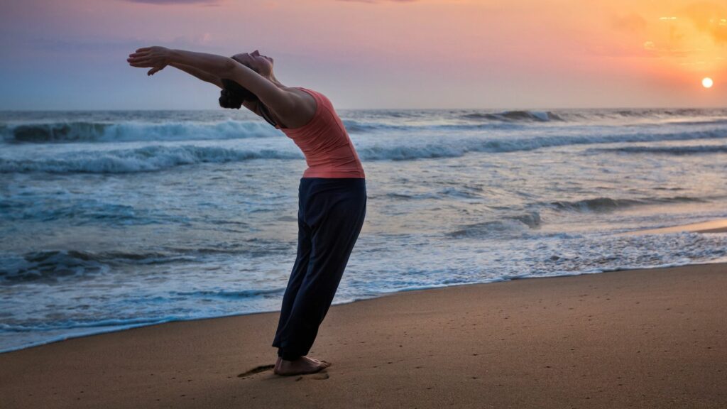 Jovem mulher em forma esportiva fazendo ioga Surya Namaskar. 