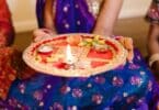 Imagem de uma mulher segurando um Puja Thali, durante a celebração do festival de Govardhan Puja.