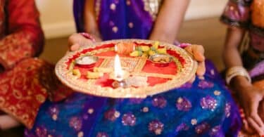 Imagem de uma mulher segurando um Puja Thali, durante a celebração do festival de Govardhan Puja.