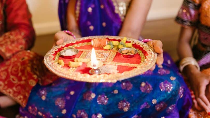 Imagem de uma mulher segurando um Puja Thali, durante a celebração do festival de Govardhan Puja.