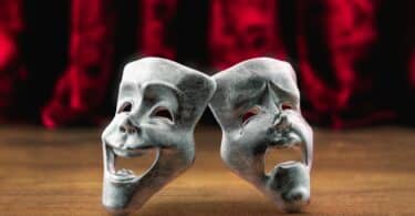 Máscaras de teatro em frente a uma cortina vermelha