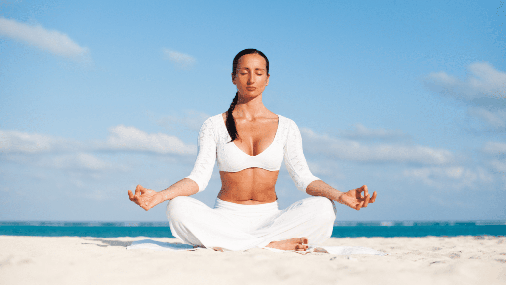 Mulher meditando na praia. 