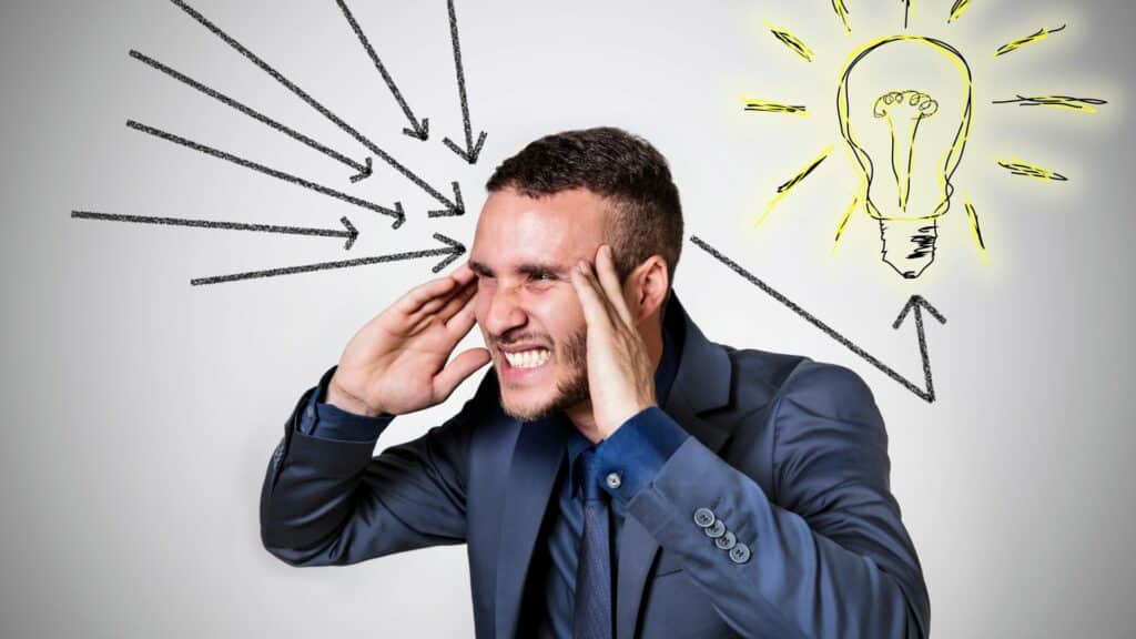 Imagem de um homem de negócios colocando as mãos na cabeça, demonstrando uma mente engenhosa para os negócios e para a competitividade.