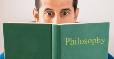 Homem lendo livro de filosofia.