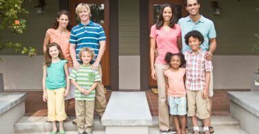 Imagem de duas famílias compostas por pais e filhos e são vizinhas. Elas estão na varada de suas casas, simbolizando o conceito de amizade e coletividade.