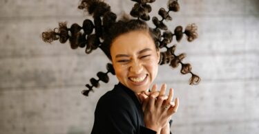 Imagem de uma mulher com um penteado único, trazendo o conceito de amor próprio, aceitação e valorização.