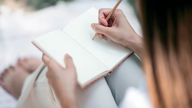 Mulher escrevendo em um caderno