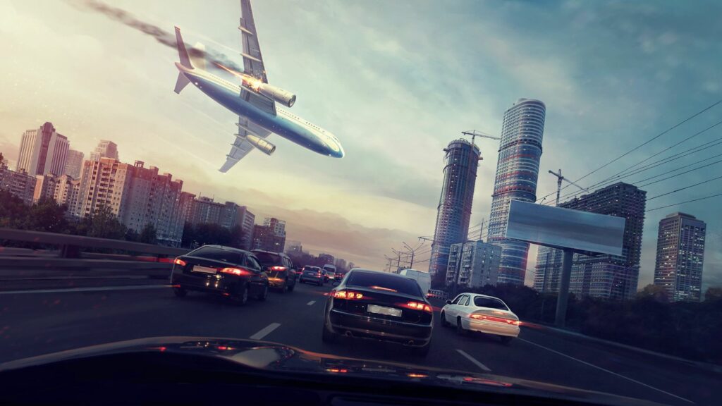 Imagem de um avião caindo dentro de uma cidade.
