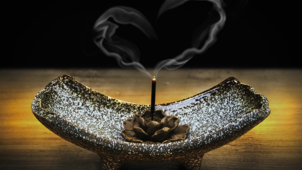 Imagem de um recipiente sendo usado para fazer a defumação com o Palo Santo.

