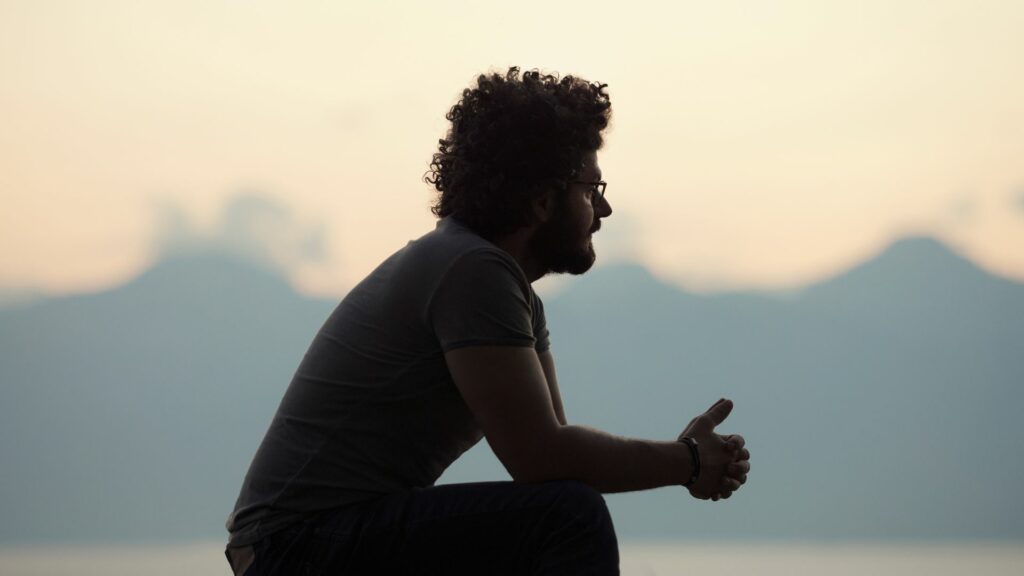 Imagem de um homem sentado se sentindo solitário.
