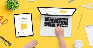 Imagem de uma pessoa usando um notebook e um tablet para criar o conceito de estratégia de marketing de uma empresa nas mídias sociais.