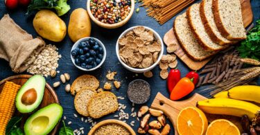 Imagem de vários tipos de alimentos ricos em fibras, dispostos sobre uma bancada.