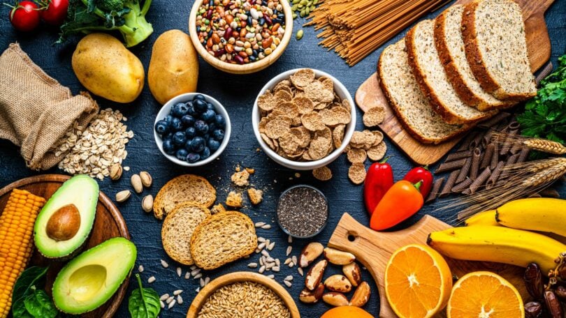 Imagem de vários tipos de alimentos ricos em fibras, dispostos sobre uma bancada.