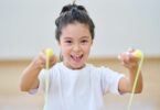 Imagem de uma menina alegre pulando com corda de pular.