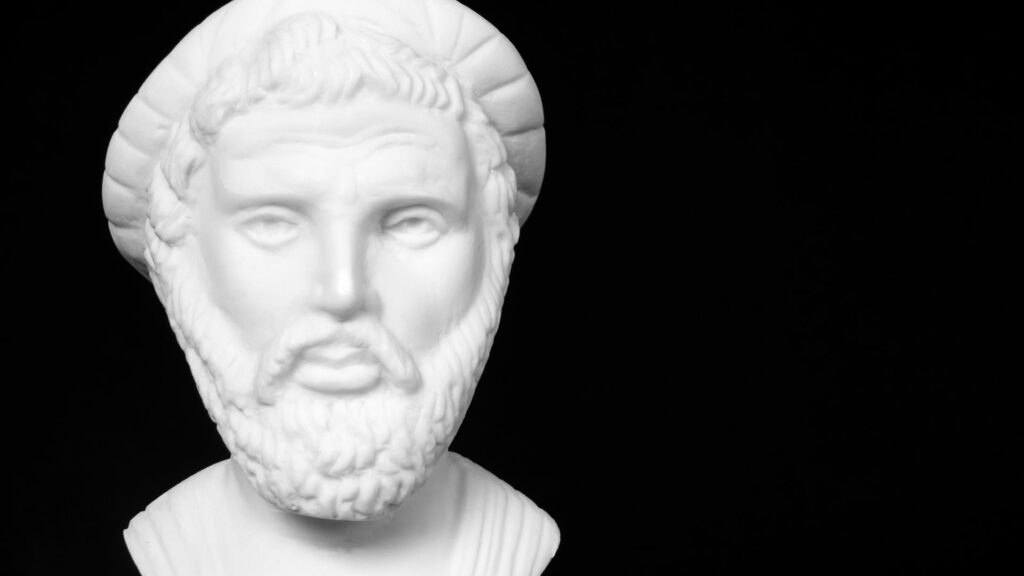 Imagem de fundo preto e em destaque o busto em gesso do filósofo Pitágoras.
