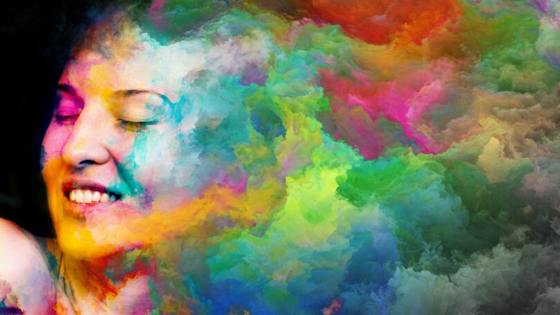 Imagem do rosto de uma mulher trazendo o conceito de eu sou, eu estou viva. A imagem traz ainda cores diversas que sombream a face da modelo.