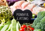 Imagem de vários vegetais, verduras e carne de frango e ao centro uma placa com os dizeres: Mindful Eating.