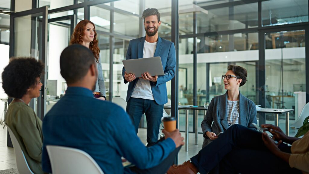 Imagem de um empreendedor reunido com os seus colaboradores em uma sala de trabalho.
