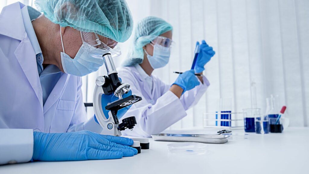 Imagem de dois cientistas pesquisadores em um laboratório estudando as células humanas.
